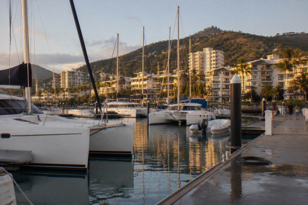 Catamarans and boats moored at a marina at golden hour