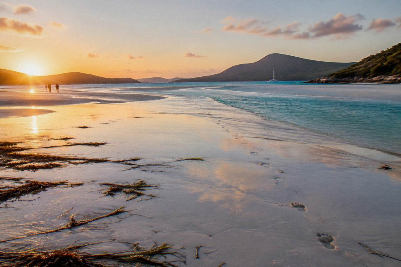 Long curve of white sand meeting turquoise shallow water at a tropical inlet