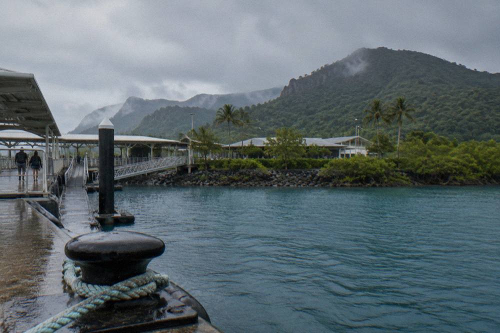 Rain clouds passing over green Whitsunday islands and dark blue sea