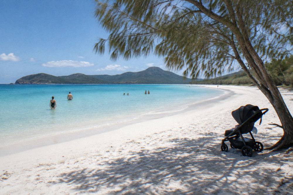 White sand beach and turquoise shallow water at a Whitsunday island bay