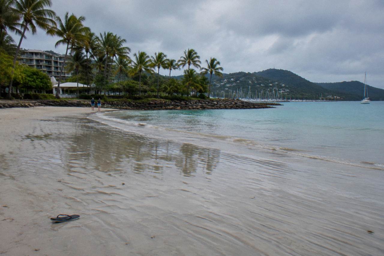 Calm sandy beach and shallow turquoise water at Boathaven Beach near Airlie Beach at low tide