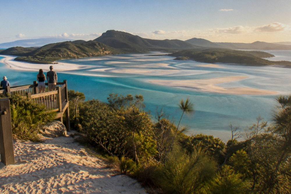 White sand beach with turquoise inlet water seen from a headland lookout