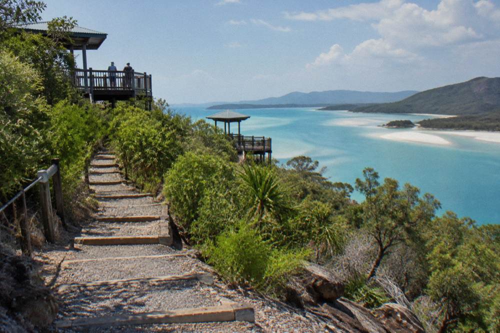Two timber lookout platforms above the green forested headland overlooking the sand swirls of Hill Inlet