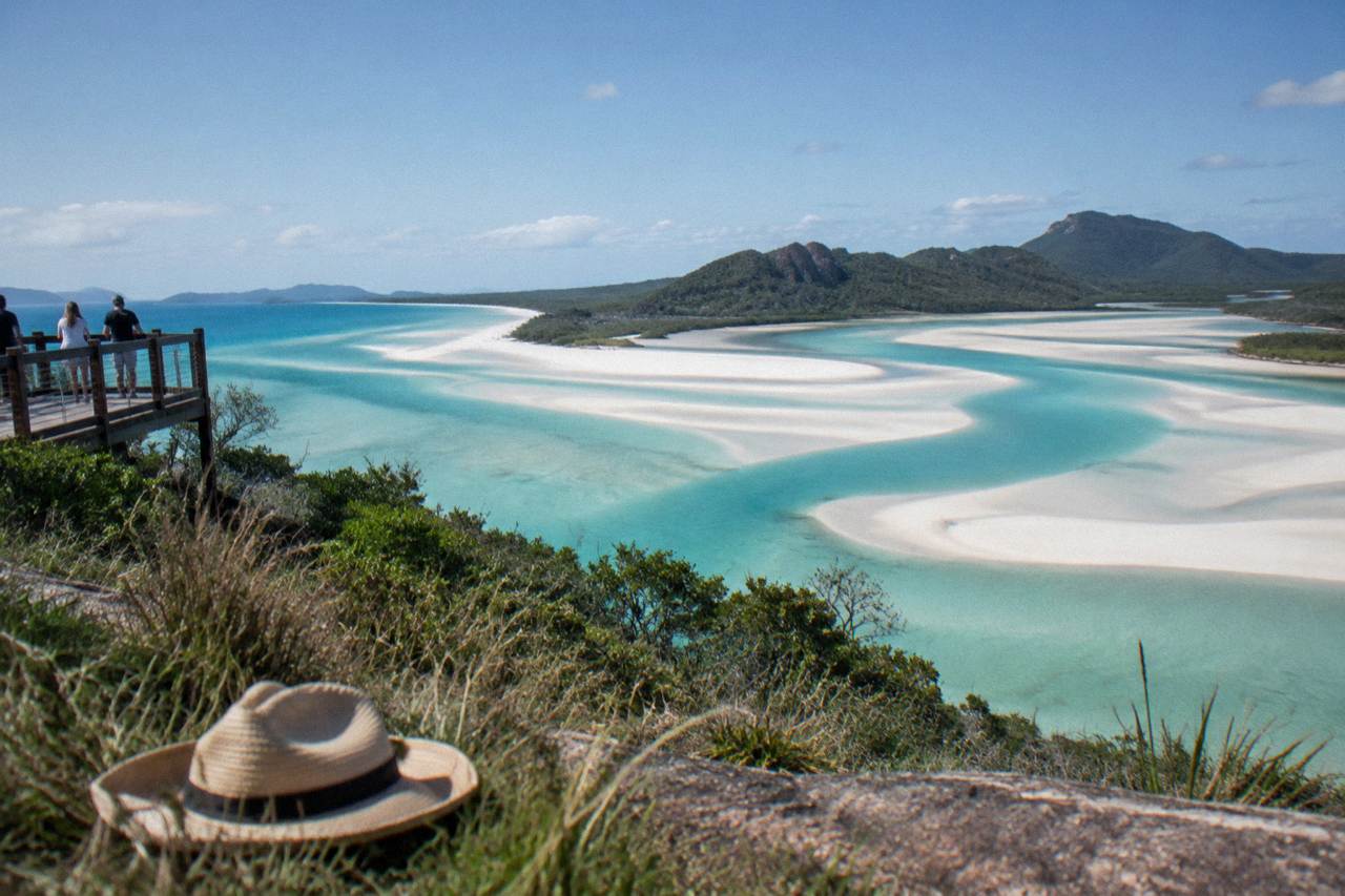 Turquoise and white swirling water where Hill Inlet meets the silica sand of Whitehaven Beach under a clear sky