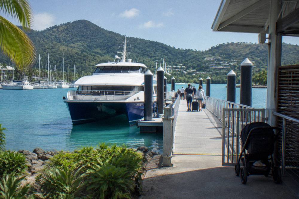 Ferry docked at a island marina terminal with passengers boarding along the pontoon