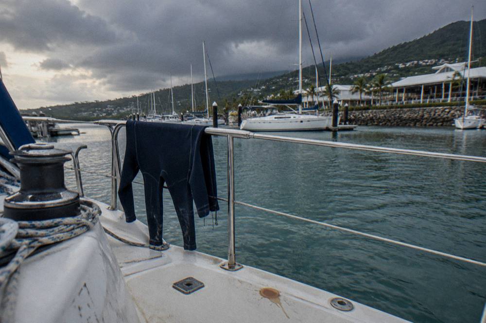 A lycra stinger suit drying on a rail at the back of a boat