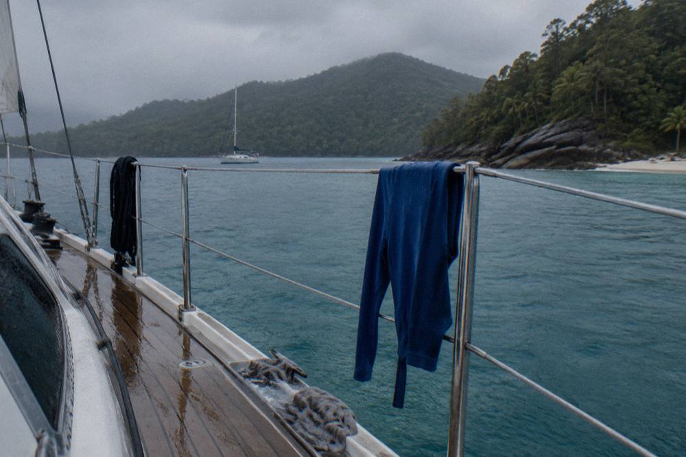 A full-length lycra stinger suit drying on the rail of a boat deck